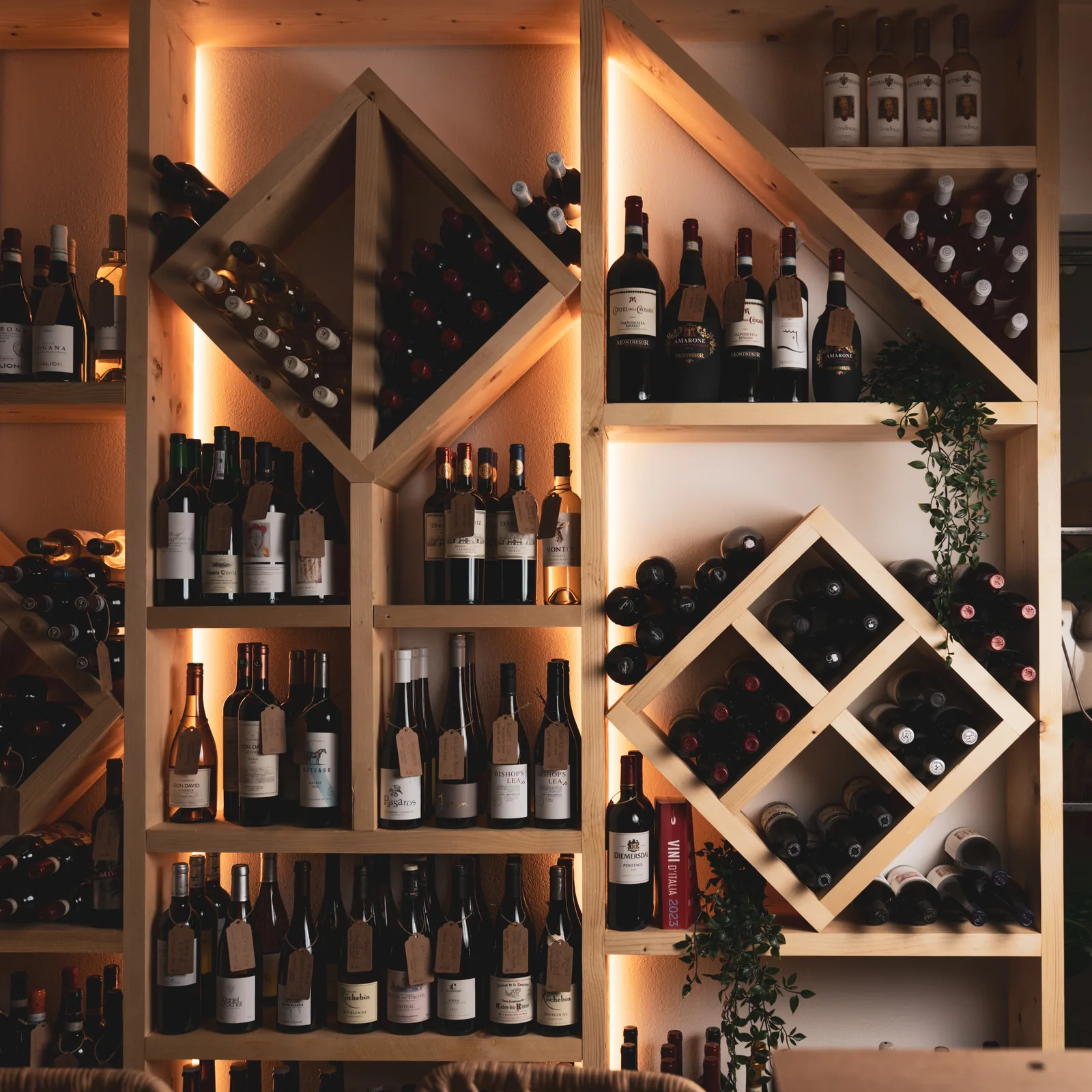 Le bottiglie dell'enoteca nelle nicchie di legno illuminate