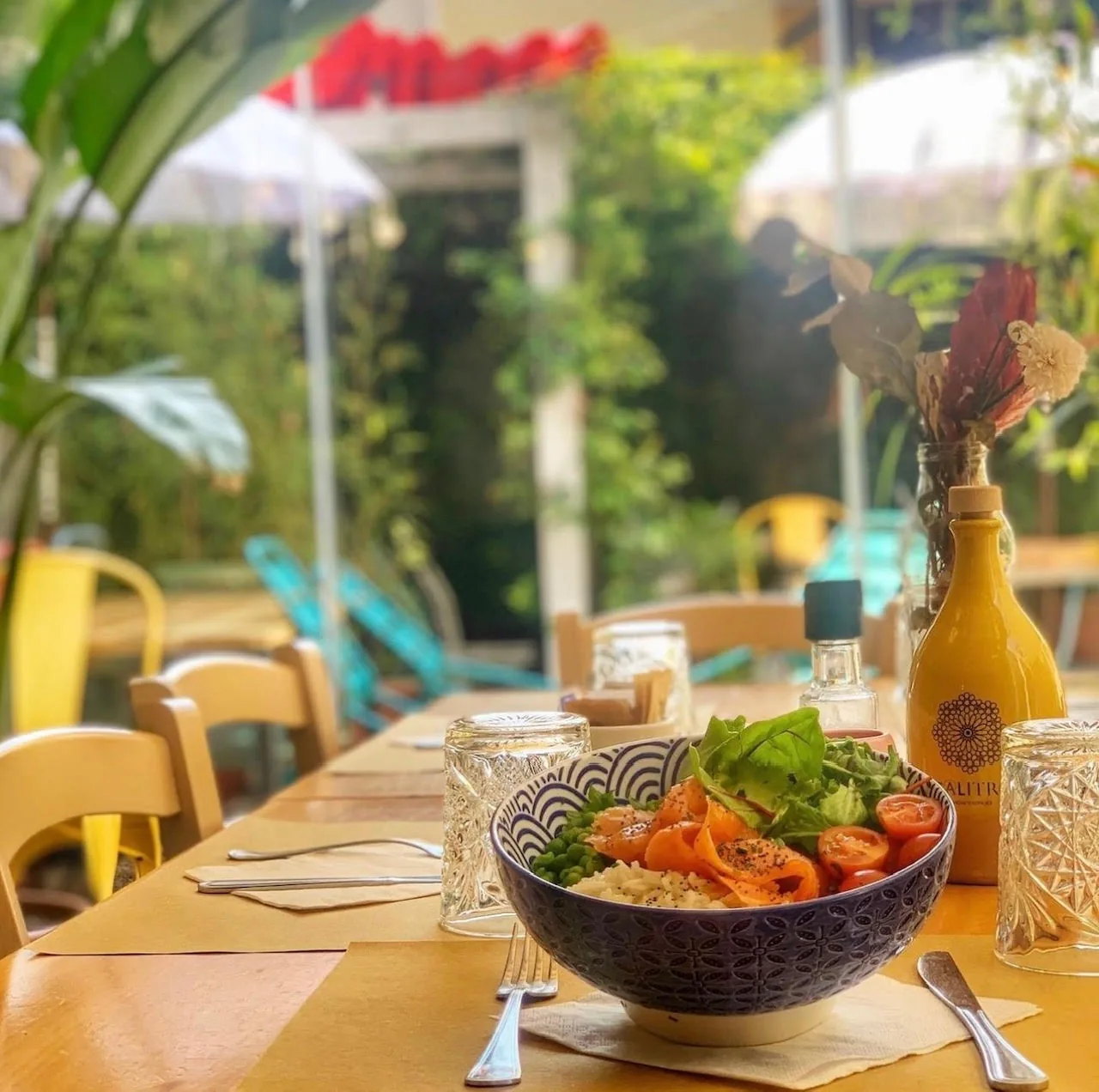 Una bowl con salmone e verdure su un tavolo del giardino